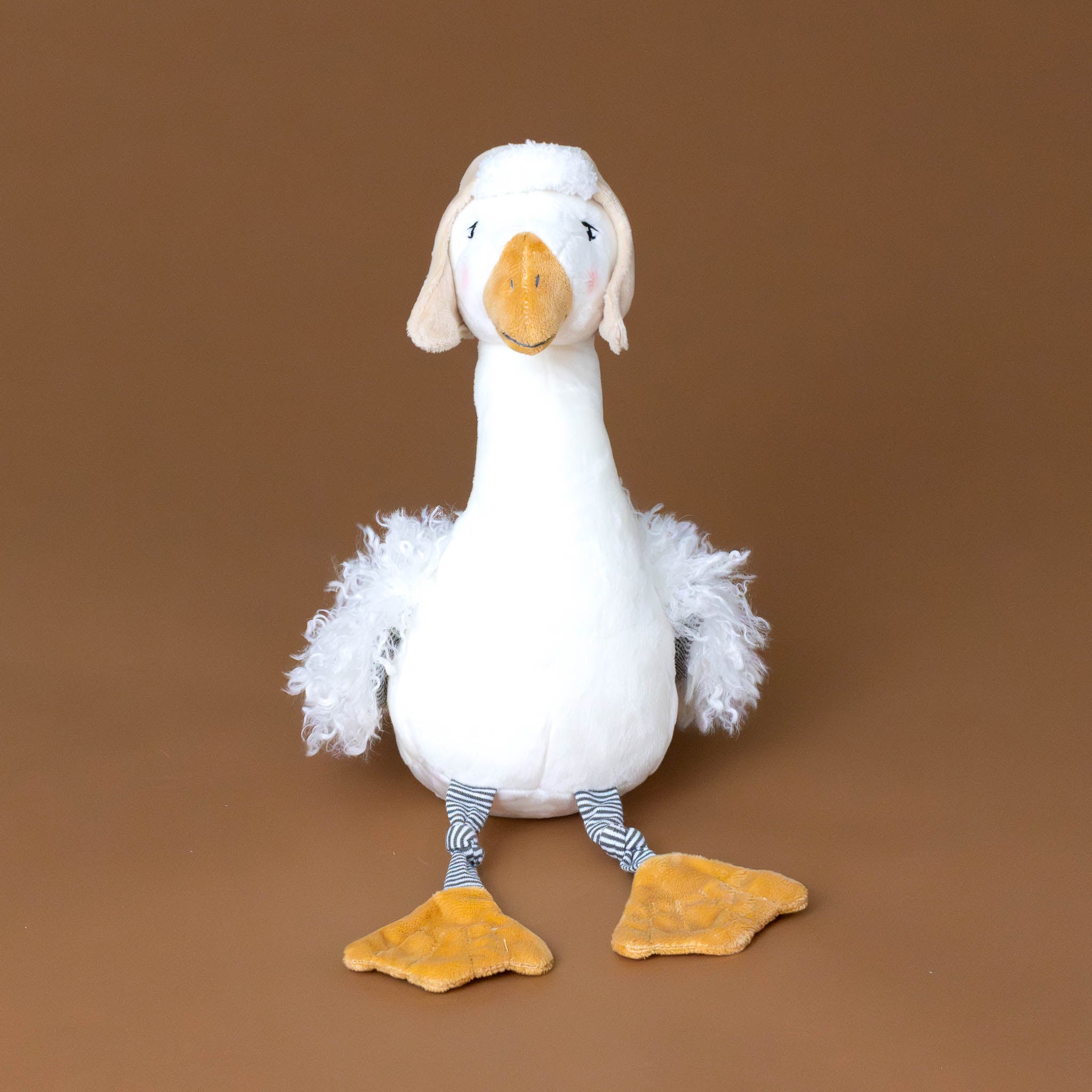 white-avery-aviator-capped-snow-goose-with-fluffy-wings-striped-legs-and-ochre-beak-and-feet-sitting