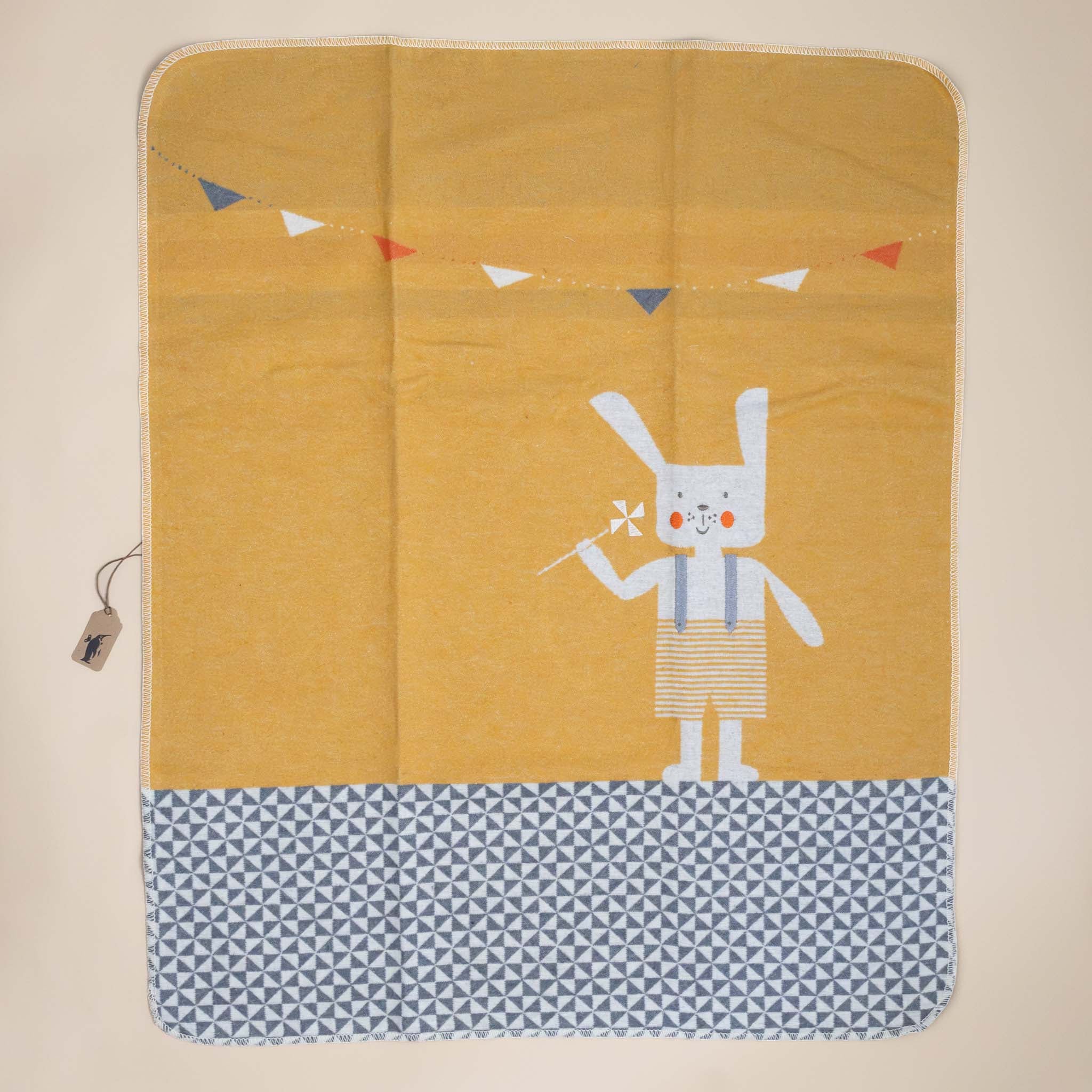 baby-blanket-embroidered-bunny-ochre-overall-shorts-holding-a-pinwheel-with-tiled-floor-and-garland-decoration