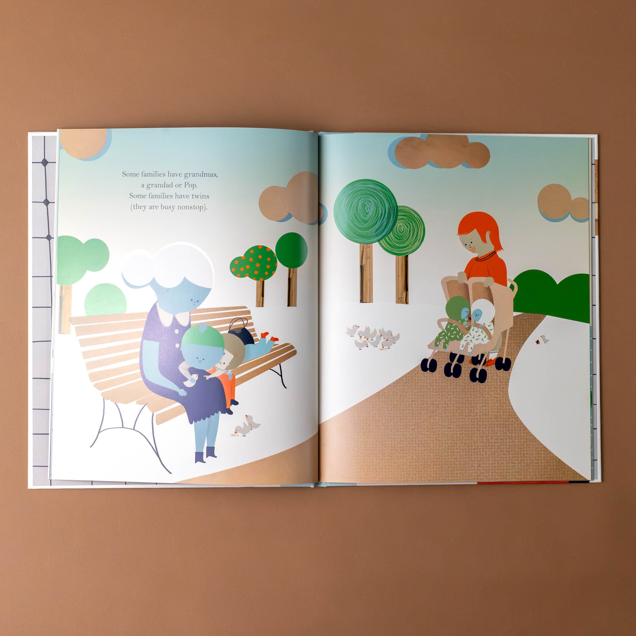 families-book-interior-with-dad-pushing-twins-in-stroller-and-grandparent-on-a-bench-with-children