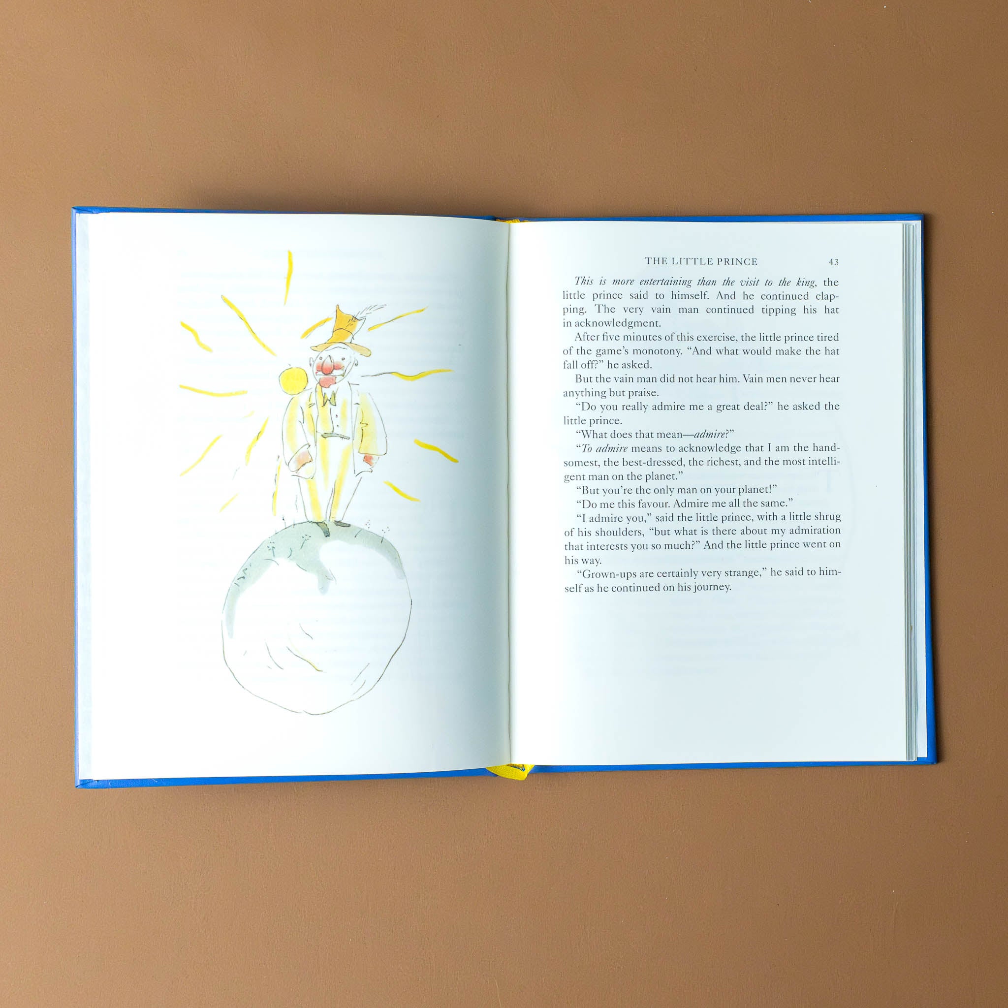 leather-bound-the-little-prince-book-interior-page-with-man-back-lit-by-the-sun-standing-on-a-planet