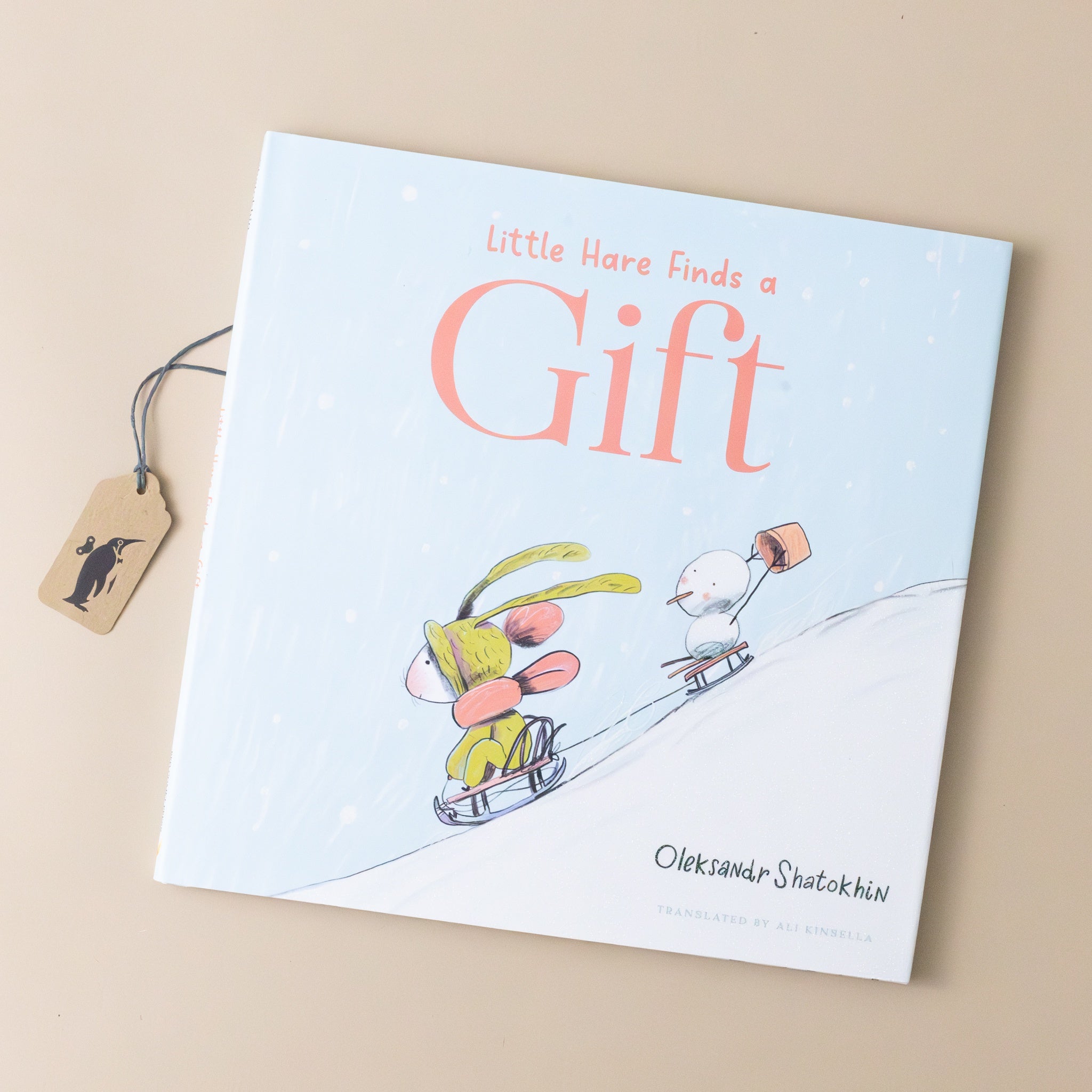 little-hare-finds-a-gift-cover-with-hare-on-a-sled-followed-by-snowman-holding-a-gift