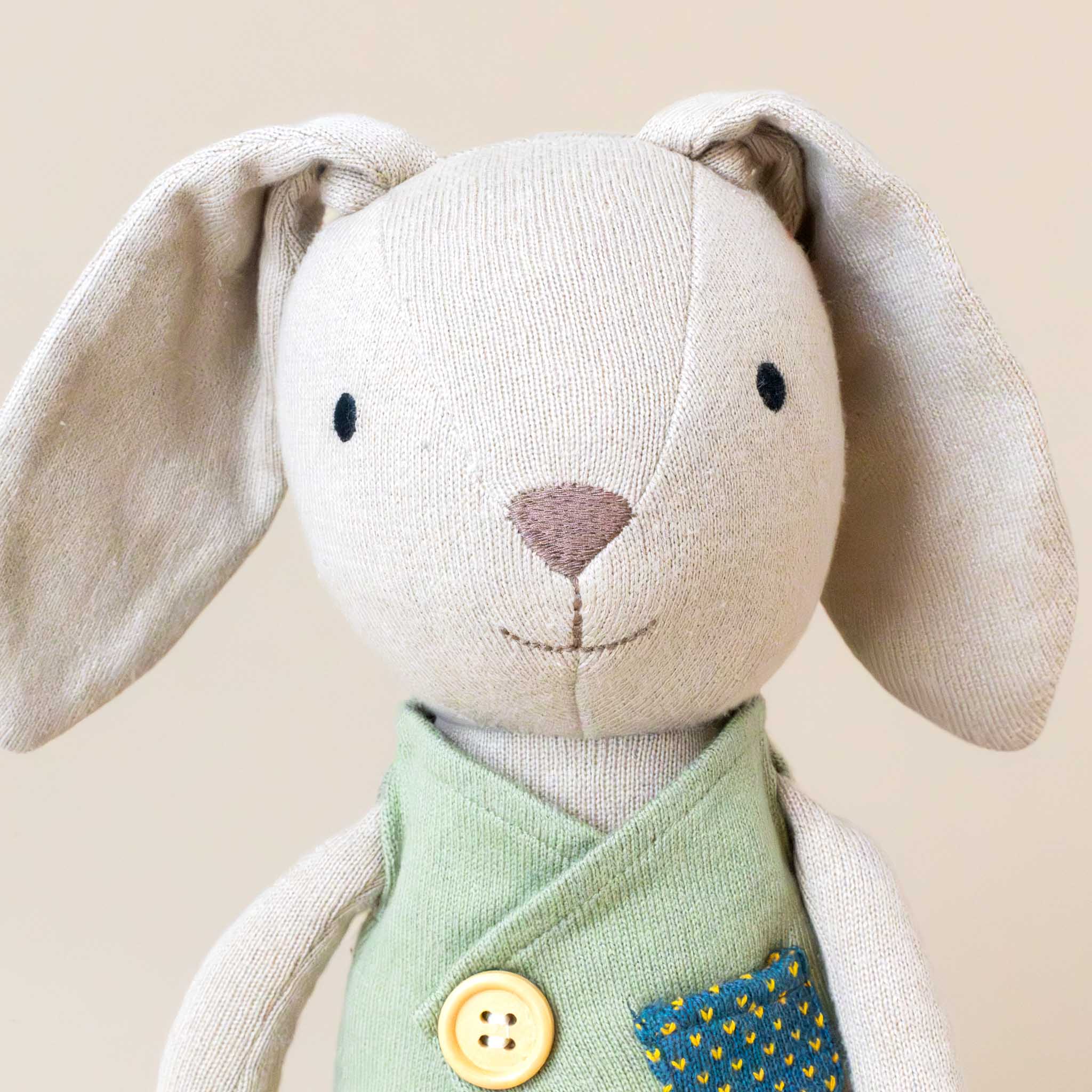 organic-knit-woodland-pal-luca-bunny-with-green-vest-stuffed-animal-face-with-embriodiered-eyes-nose-mouth