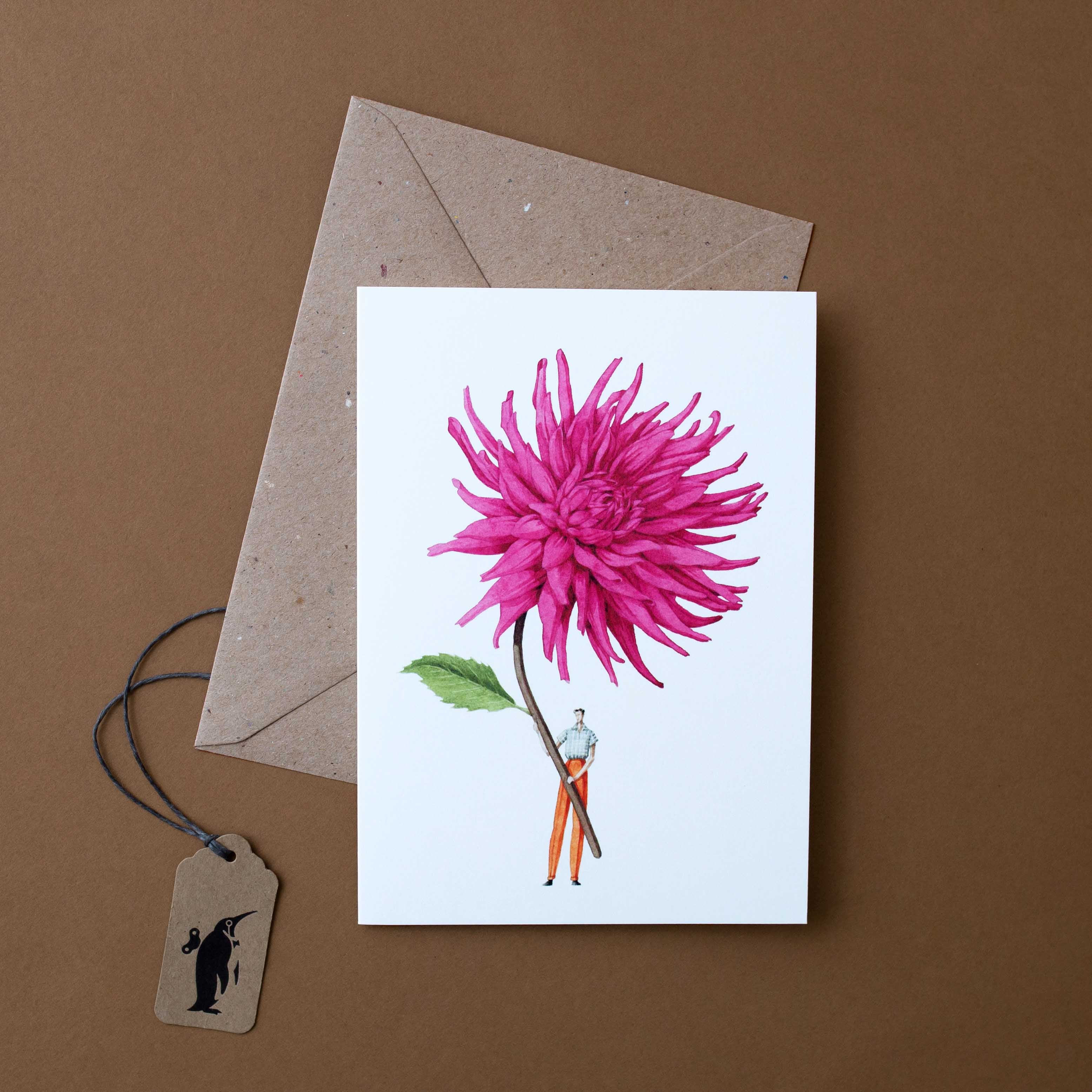 man-holding-oversized-pink-dahlia-on-white-background-with-craft-envelope